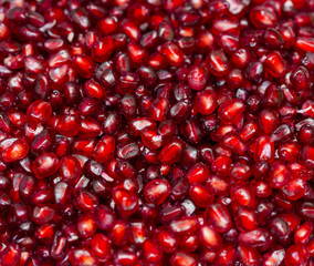 Red background of pomegranate seeds close-up