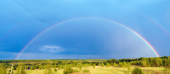 Beautiful nature landscape with double full rainbow above field panorama