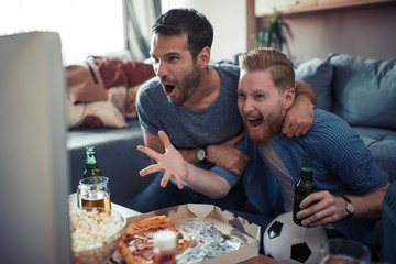 Friends enjoy football game on TV