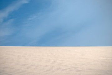 Patterns, wrinkles and other details of erosion at white beach sand in the dunes