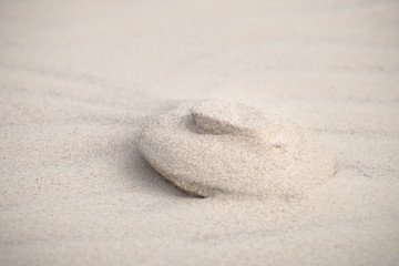 Patterns, wrinkles and other details of erosion at white beach sand in the dunes