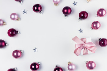 Christmas flat lay frame with pink abd violet glass balls and gift box