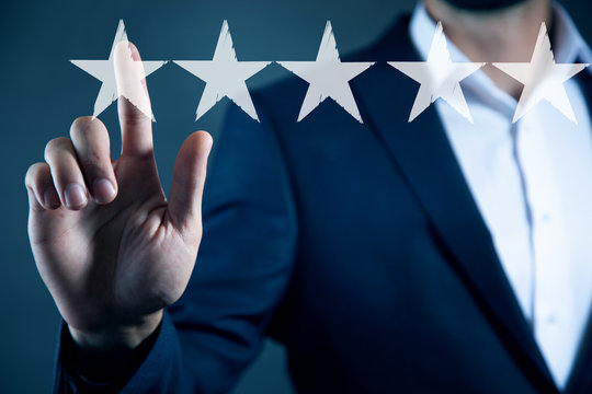 man touching five stars in screen