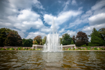 Large fountain with multiple heights in a baroque garden surrounded with Colonnades