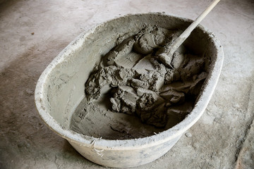 bucket of mixed cement mortar for plaster wall or welding brick. image for building construction concept.