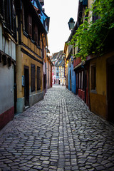 Fototapeta premium Sunrise in the old town of Colmar, Alsace, France on a sunny day. Small street and traditional half timbered houses. Also known as Petit Venice.