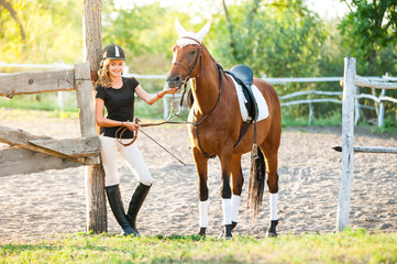 A beautiful girl rider walks with a horse. Horse theme