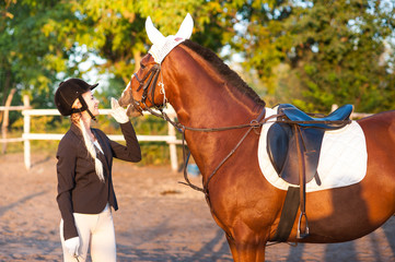 A beautiful girl rider walks with a horse. Horse theme