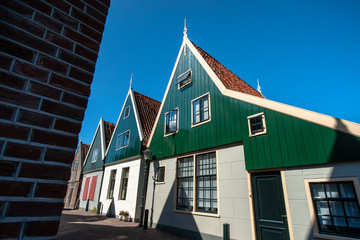 Characteristic Dutch architecture of wooden house with vivid colors and beautiful half-timbered details. Atmospheric vistas of streets and canals in a Dutch village