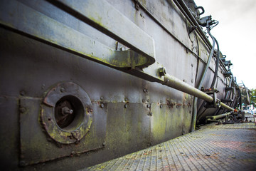 Old steam boiler with water pipes on urbex locomotive, authentic industrial details and craftsmanship along the rail way and station