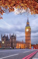 Fototapeta na wymiar Buses with autumn leaves against Big Ben in London, England, UK