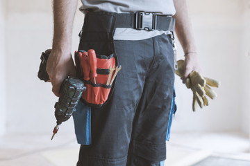Professional repairman standing and holding a drill