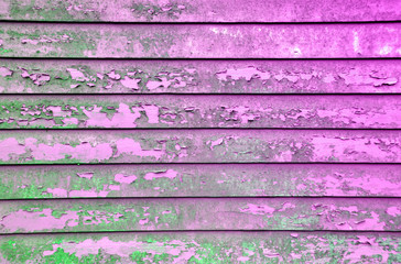 Rusty vintage wall. Rough green texture on an former lilac surface. Weathered wooden planks.