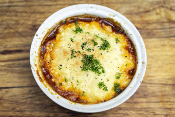 traditional british cottage pie bowl meal on rustic wood table