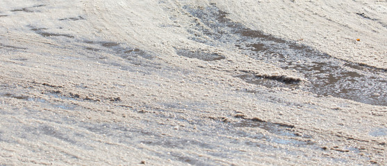 the car drives on wet and dirty asphalt on a winter road