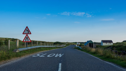 Road near Mallaig, Scotland, with "SLOW" lettering near a curve