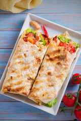 Chicken bacon wraps with tomatoes, lettuce and cheese. Tortilla, burritos, sandwiches twisted rolls. overhead, vertical