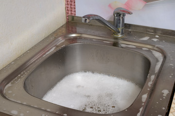 the drain hole was blocked. The sink is filled with water and foam