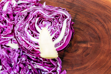Obraz premium cut purple cabbage, one whole half and another chopped on wooden board