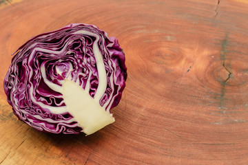 Half of purple cabbage on wooden board