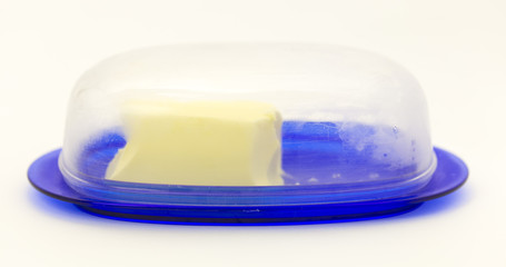 creamy solid oil on a plastic container on a white background