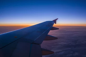 Fototapeten Schöner Sonnenuntergang mit Himmel vom Flugzeugfenster zur blauen Stunde © Marc Kunze