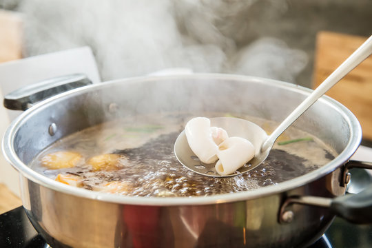 Shabu Shabu and Sukiyaki black soup, show squid slice on ladle. healthy food japanese style. image for objects and copy space.