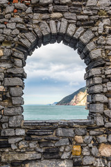 Sea view from a stone window of an old ruin castle wall in Portovenere, Liguria, Italy.