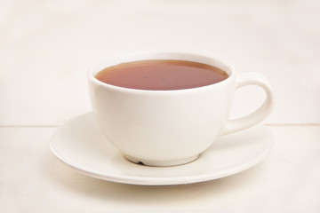 porcelainl cup with green tea on table
