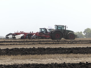 Exhibition of agricultural machinery. Agrotechnics works in the field. The tractor pushed the field. Plowed earth.