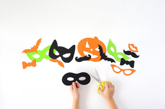 Halloween. The paper masks on a white background which are cut out from paper