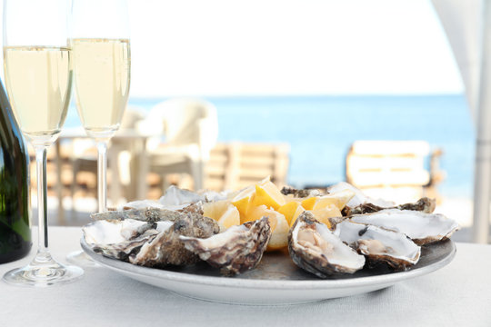 Fresh oysters with cut juicy lemon served on table