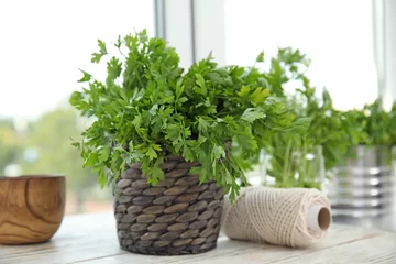 Photo sur Plexiglas Herbes Wicker pot with fresh green parsley on window sill