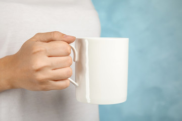 Woman holding ceramic cup on color background. Mock up for design