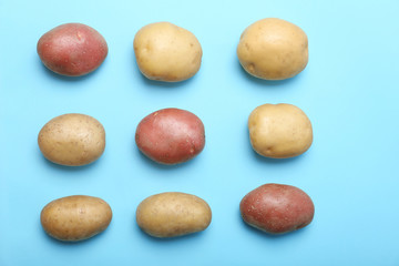 Fototapeta na wymiar Flat lay composition with fresh organic potatoes on color background
