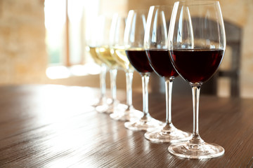 Glasses of white and red wines on wooden table