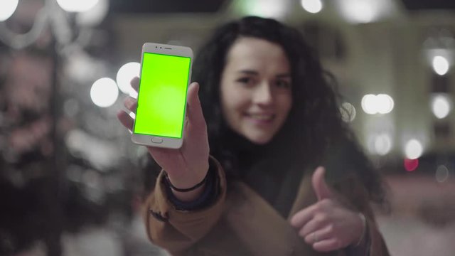 Young Girl is Holding Smartphone with Green Screen at Evening Time. Casual Lifestyle