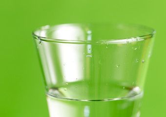 a glass of water on a green background