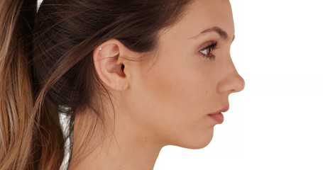 Side portrait of lovely young Caucasian female on white copy space