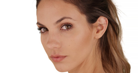 Fototapeta premium Tight shot of gorgeous young lady turning towards camera on white copy space
