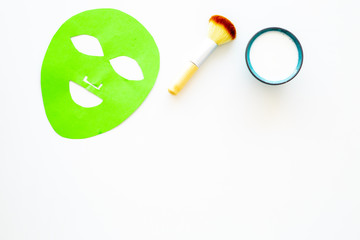 Cosmetic product for cleansing skin. Facial mask, cream and brush on white background top view copy space