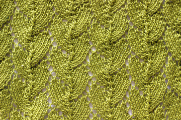 Knitted fabric with an openwork pattern, handmade. Background, texture