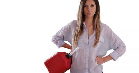Millennial girl holding red gas can posing with hands on hips on white backdrop