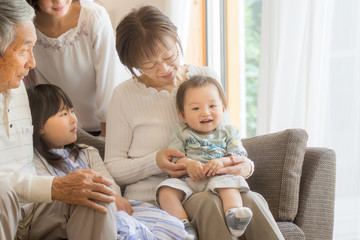 Obraz premium おばあちゃんの膝でにっこり微笑む赤ちゃん