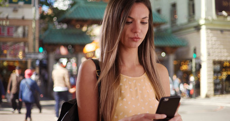 Woman in her 20s taking photo of herself with phone in San Francisco Chinatown