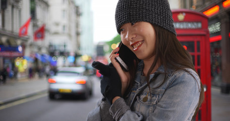 Lovely young woman talking on smartphone in a cold European city