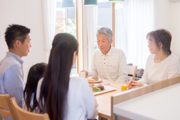 自宅で食事を楽しむ三世代家族