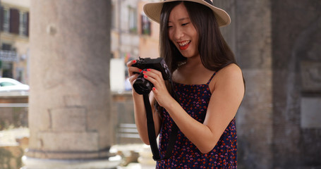 Obraz premium Closeup of Asian millennial photographer taking pictures in Rome Italy