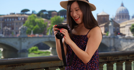 Fototapeta premium Closeup of Asian millennial photographer taking pictures by the Vatican in Rome