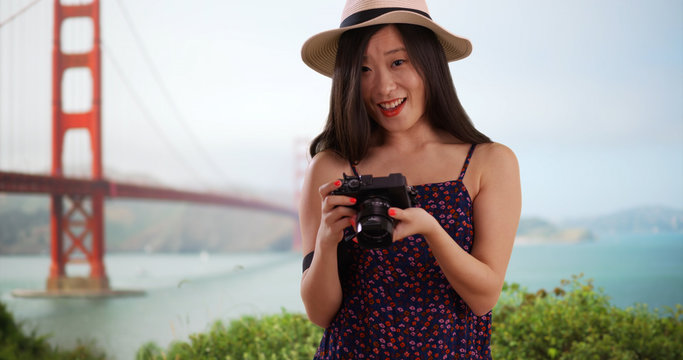 Close up of young tourist using camera by Golden Gate bridge in San Francisco